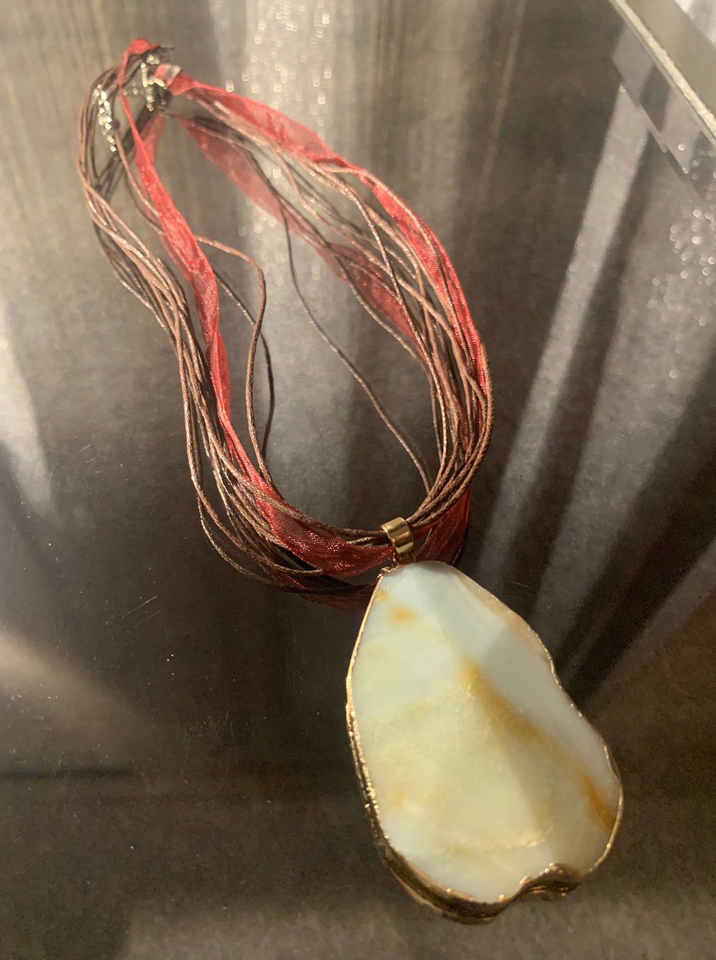Necklace, Natural Cream Sun Burst Stone Pendant Accented with Rust and Amber Nylon Ribbon and Cords 18" Necklace with lobster clasp and extension chain