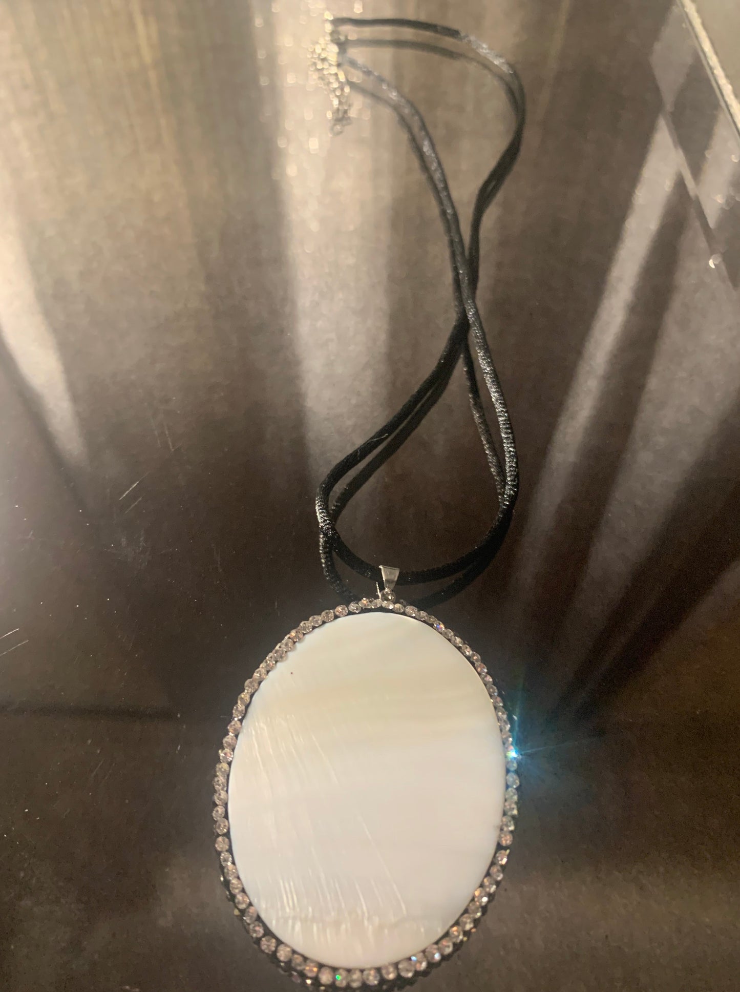Necklace, Reversible Iridescent Shell Pendant Trimmed in Rhinestones with Black Nylon Cord 18" Necklace with lobster clasp and extension chain.